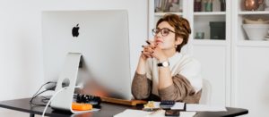 Woman at computer thinking about answers to 5 B2B marketing questions