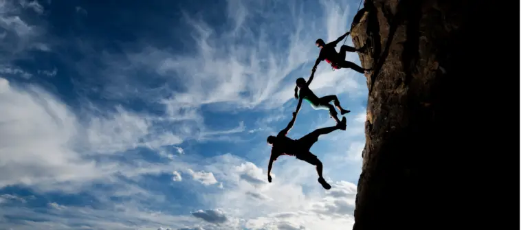 Three people rock climbing together represent trust in B2B marketing.