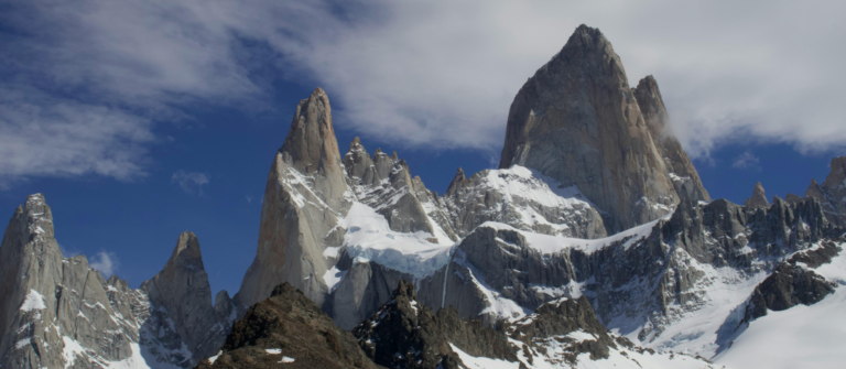 Snow-covered mountain peaks rising above rugged terrain symbolize momentum and long-term growth tied to the ROI of content marketing.